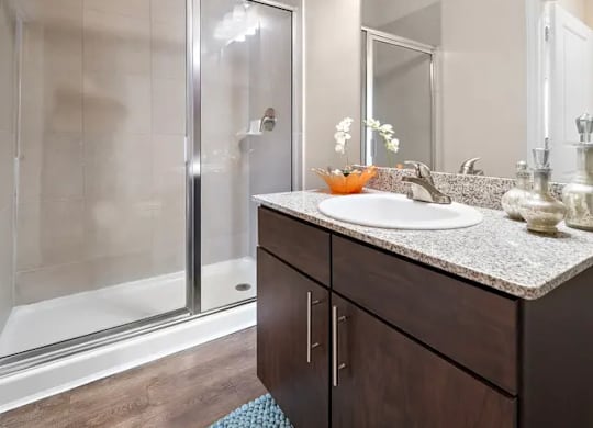 A modern bathroom with a sink, mirror, and shower.
