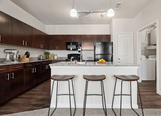 A kitchen with a white countertop and dark wood cabinets.