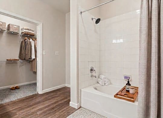 A white bathroom with a white tub and a white shower curtain.