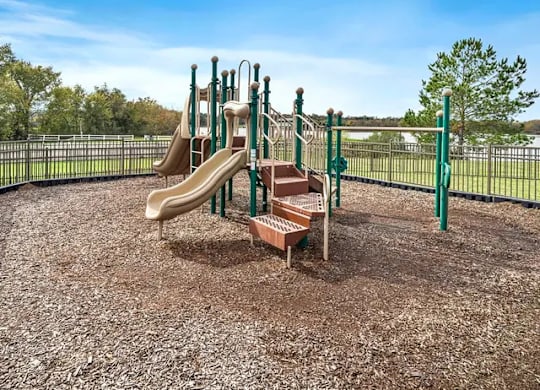 A playground with a slide and a climbing frame.