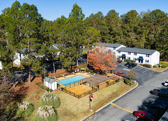 an aerial view of a property with a swimming pool and tennis court