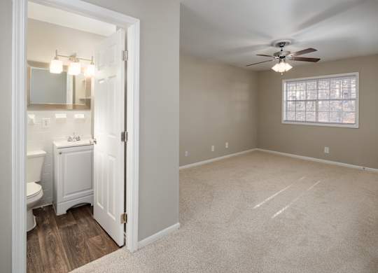 a bedroom with a ceiling fan and a bathroom