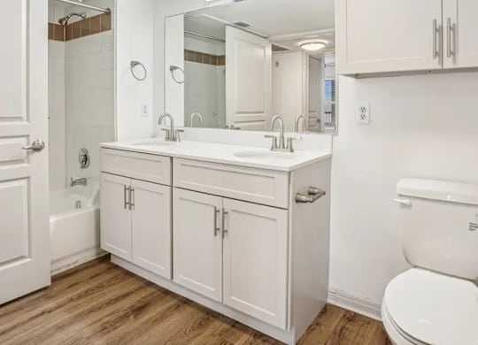 A white bathroom with a toilet, sink, and mirror.