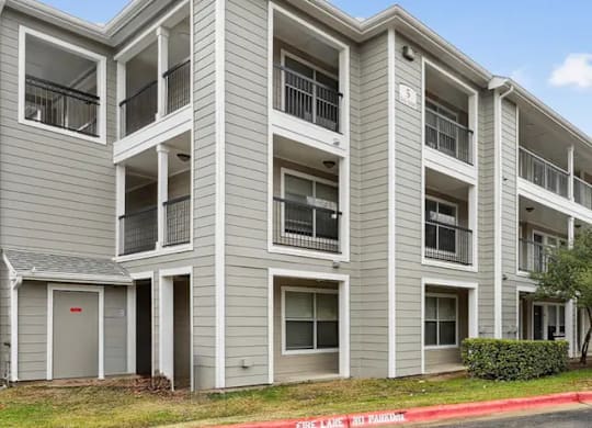 A multi-story apartment building with balconies and doors.