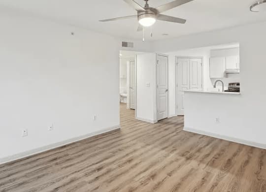 A room with a ceiling fan and wooden flooring.