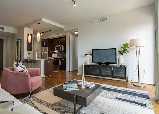 A modern living room with a pink armchair and a black coffee table.