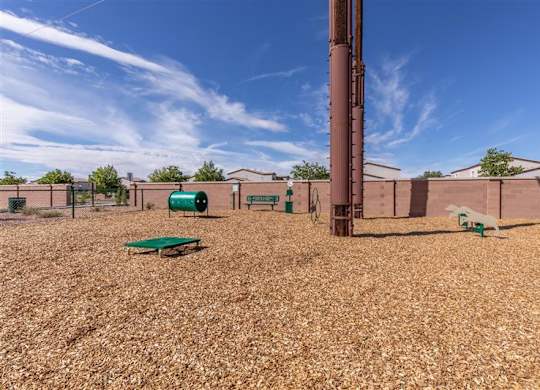 A playground with a green slide and a brown pole.