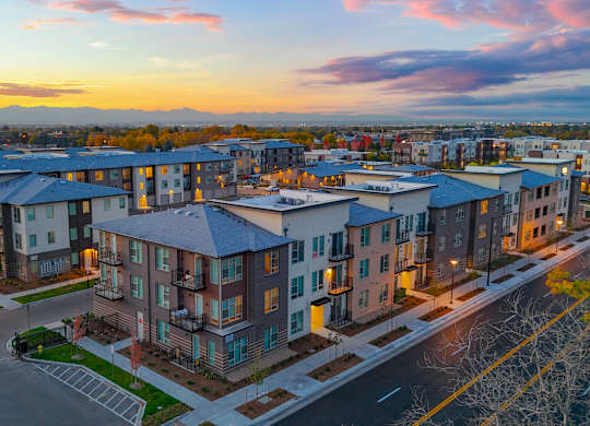 A sunset view of a residential area with apartment buildings.