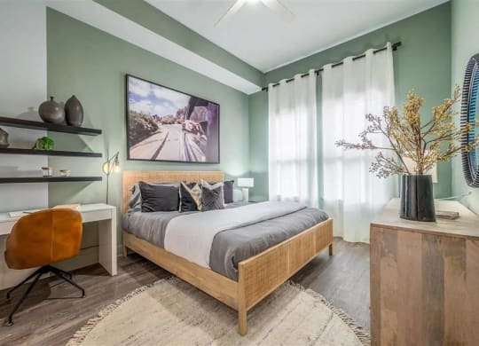 a bedroom with green walls and a bed and a desk
