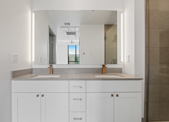 a bathroom with two sinks and a large mirror