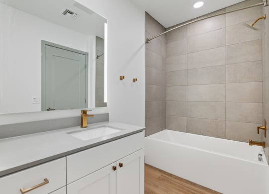 a bathroom with a sink and a tub and a mirror