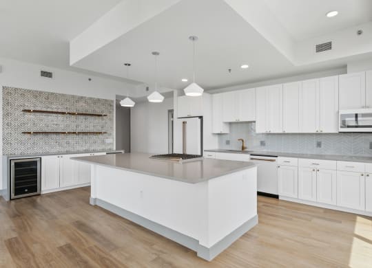 a large white kitchen with a large island and white cabinets