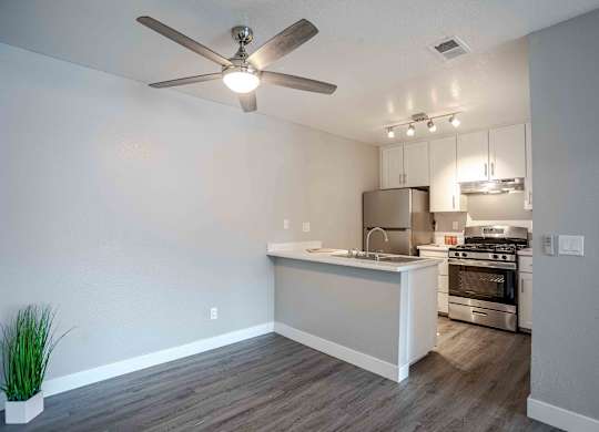 an open kitchen and living room with a ceiling fan