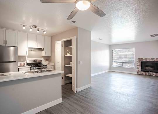 an open kitchen and living room with a ceiling fan