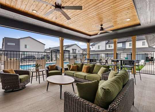A patio with a table and chairs and a ceiling fan.