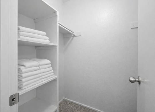 A white bathroom with a towel rack and towels.