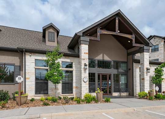 A modern building with a stone facade and a large glass entrance.