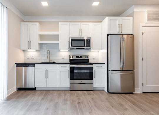 A modern kitchen with stainless steel appliances and white cabinets.