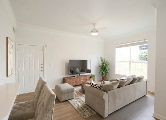 A living room with a couch, chair, and television.