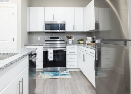 a kitchen with white cabinets and stainless steel appliances