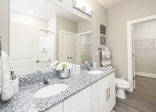 a white bathroom with two sinks and a mirror