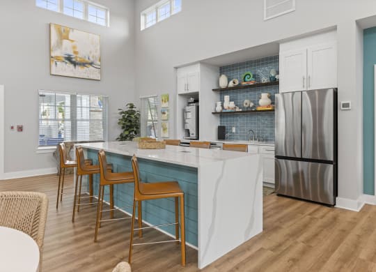a kitchen with a marble counter top and stainless steel refrigerator