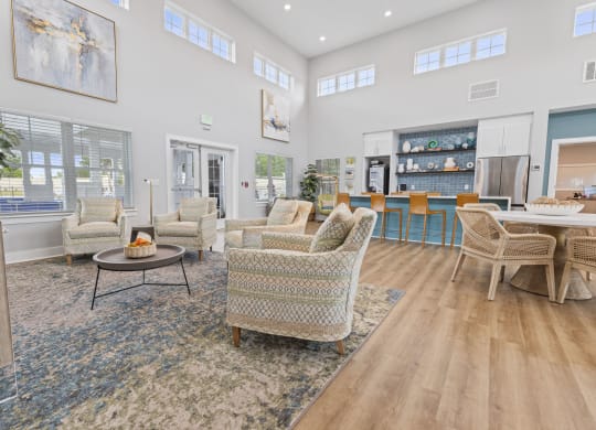 a living room with couches and chairs and a kitchen with a table