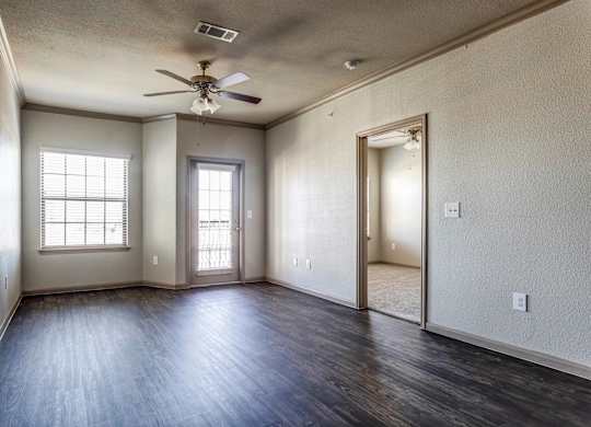 an empty living room with a ceiling fan