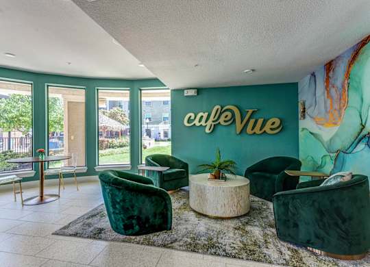 a lobby with green chairs and a green wall with the words café vue on it