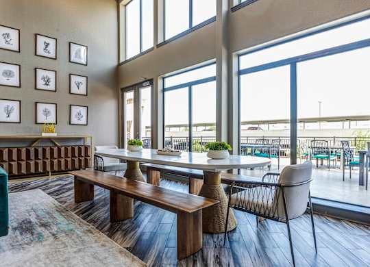 a dining area with a table and chairs and large windows