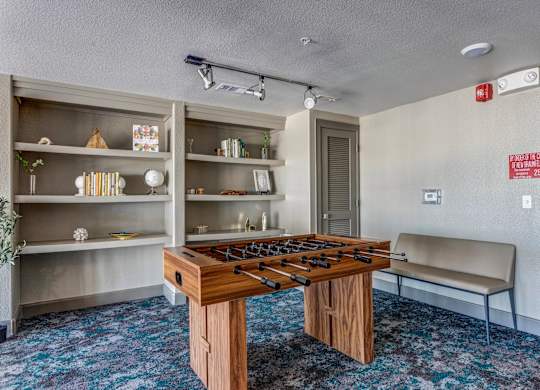 a room with a foosball table and a bench
