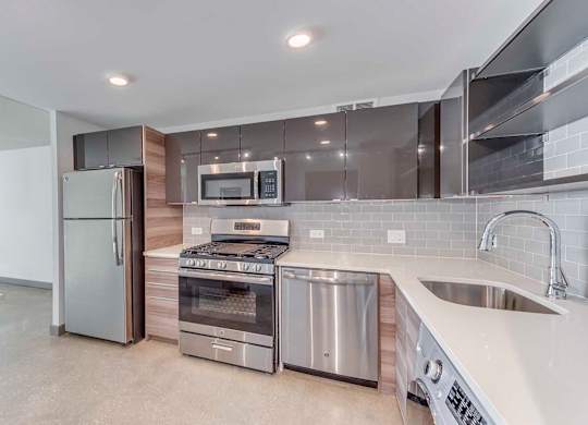 A modern kitchen with stainless steel appliances and a large island.