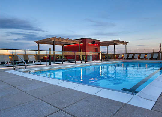 A swimming pool with a red building in the background.
