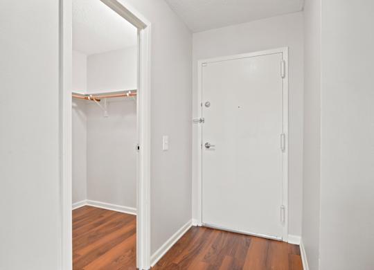 A walk-in front hall closet next to an apartment front door.