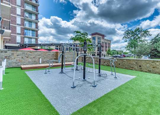 A playground with a green surface and a grey area in the middle.