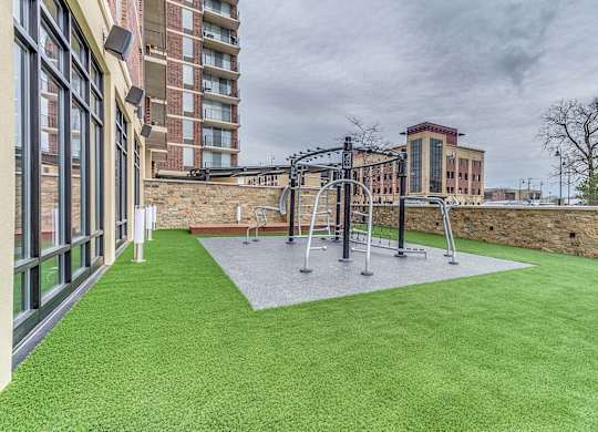 A playground with a swing set and a green lawn.