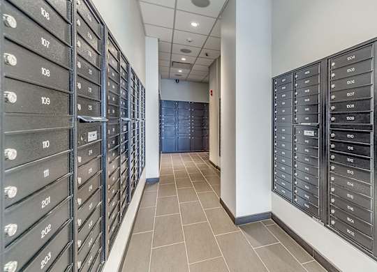A hallway with a row of mailboxes on the left and right side.