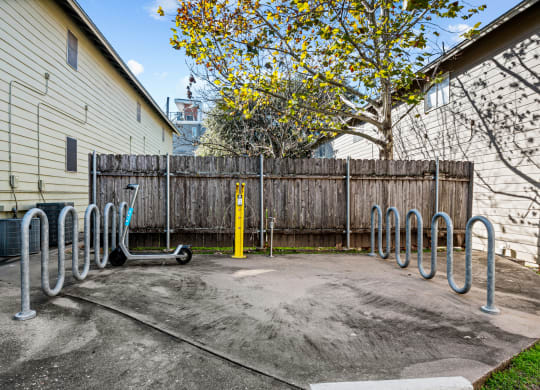 the back yard of a house with a bike rack and a fence