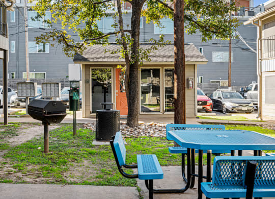 a picnic area with tables and chairs in front of a building