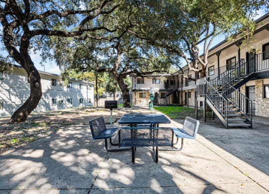our apartments have a patio with a table and chairs and trees