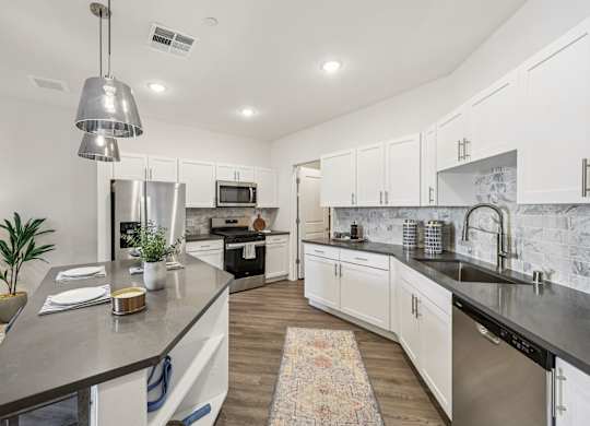 A modern kitchen with a large island and stainless steel appliances.at Fora Apartments, Las Vegas, NV 89183