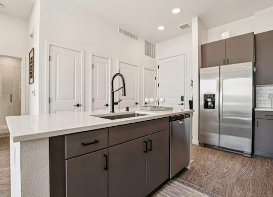 A modern kitchen with a white countertop and dark brown cabinets. at Lura Vegas Apartments, Las Vegas, Nevada