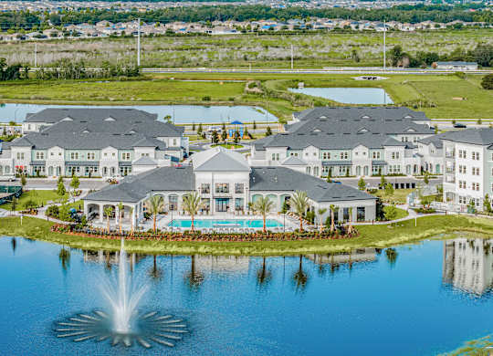 A large, well-maintained resort with a fountain in the foreground.