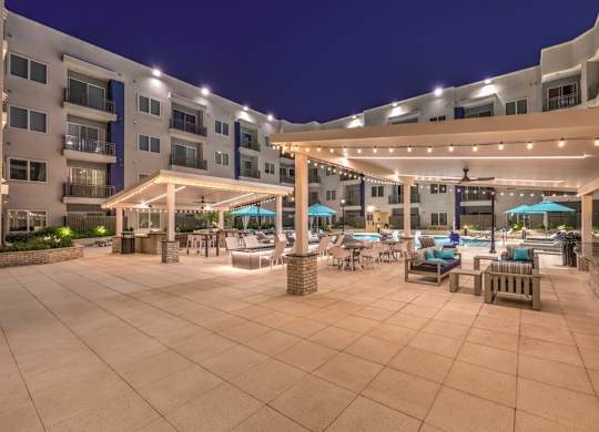 A large outdoor patio area with tables and chairs under a canopy.