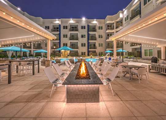 A lit fire pit is the centerpiece of a rooftop patio.