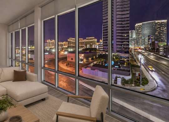 A living room with a view of the city at night.
