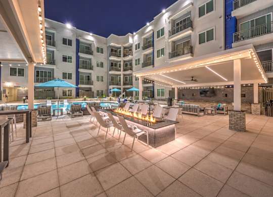 A large outdoor patio area with a fire pit and seating area.