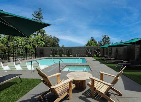 Outdoor pool with hot tub and wooden lounge chairs at Montage Apartments, Oregon