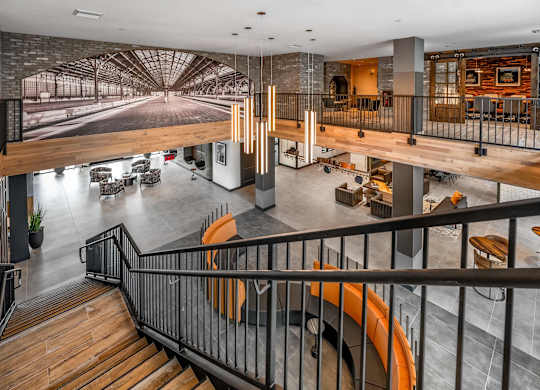 A modern interior with a staircase and a large mural on the wall at Parkway Crossings Apartments, Kissimmee