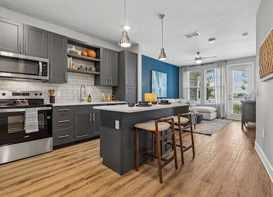 A modern kitchen with dark wood cabinets and a large island.